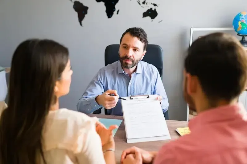 A migration consultant pointing at a training visa application form during a client meeting at PACE Migration & Education Consultancy.