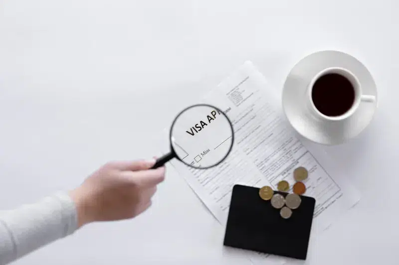 Pace Migration & Education Consultancy is a skilled migration agent in Sydney examining a visa application form with a magnifying glass.