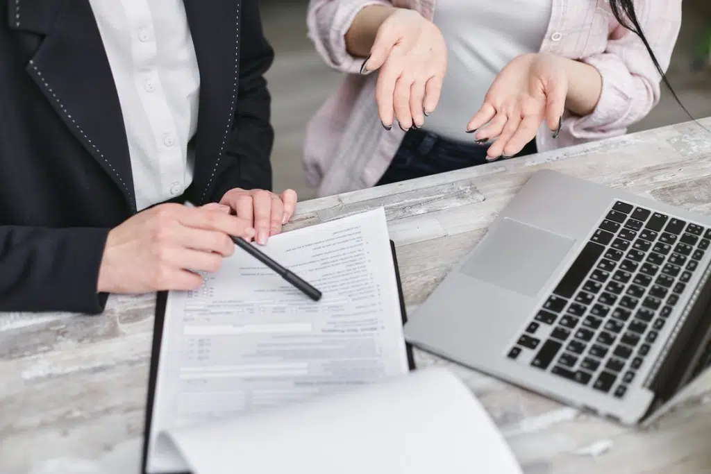 Two Pace Migration advisers in Sydney examine salary and visa documents beside a laptop for 482 and 186 visa planning